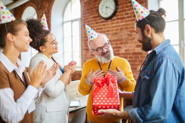 Colegas de trabalho dando presente de aniversário parao chefe.